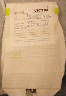 Forensic examination clothing collection photo showing sealed and labeled evidence bag