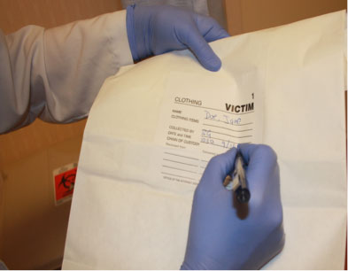 Forensic examination clothing collection photo showing nurse labeling evidence bag